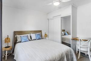 een slaapkamer met een groot bed en een spiegel bij Pearl On Beech 125 Beech Street in Evans Head