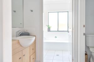 a white bathroom with a sink and a toilet at Sunrise on Terrace Unit 3, 21 Terrace Street Evans Head in Evans Head +17 photos