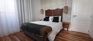 1 dormitorio con 1 cama grande con sábanas y almohadas blancas en Casa da Açoteia en Faro