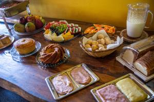 einem Holztisch mit vielen verschiedenen Arten von Speisen in der Unterkunft Hotel Fazenda Filhos do Vento in Cachoeiras de Macacu