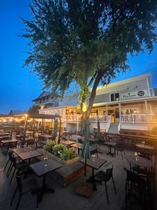 a restaurant with tables and chairs and a tree at Auberge des Cantons in Magog-Orford