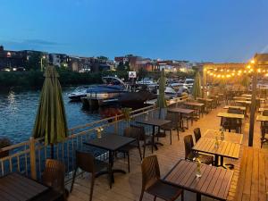 a row of tables and chairs on a dock with boats at Auberge des Cantons in Magog-Orford