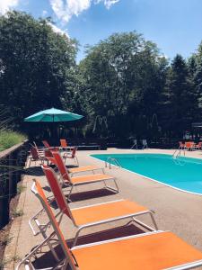 a group of chairs and an umbrella next to a swimming pool at Starlite Resort in Saugatuck