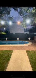una piscina con jarrones y luces en un patio en La casa de las Luces en Villa Carlos Paz