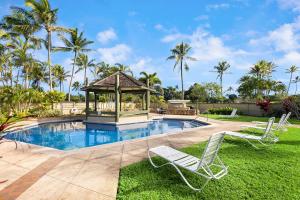 a gazebo and two lawn chairs next to a swimming pool at Kuilima Estates West 120 in Kahuku