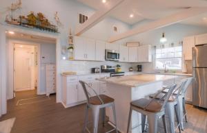 a kitchen with white cabinets and a island with bar stools at 131 #4 North Shore Boulevard East Sandwich - Waters Edge #4 in East Sandwich
