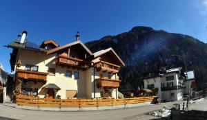a large building with a mountain in the background at Verda Val in Campitello di Fassa