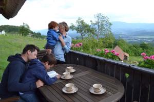 une famille assise à une table en bois avec des tasses dessus dans l'établissement Holiday home in Srednje Grcevje - Kranjska Krain 26095, à Srednje Grčevje