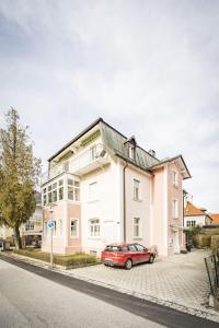 un coche rojo estacionado frente a una casa en Haus Alpenruhe en Bad Reichenhall