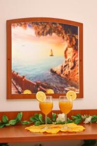 zwei Gläser Orangensaft auf einem Tisch mit einem Bild in der Unterkunft Apartments Katušić in Cavtat