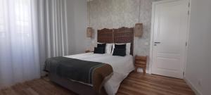 een slaapkamer met een groot bed en een witte deur bij Casa da Açoteia - Bright City Center Apartment with a Private Outdoor Terrace in Faro