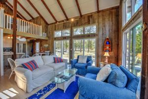 a living room with a white couch and blue chairs at Sun Serenity at A Wave From It All in Pocasset