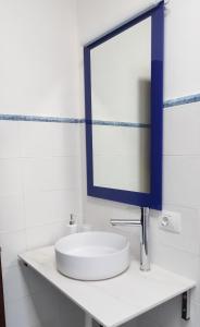 W białej łazience znajduje się umywalka i lustro. w obiekcie Casa Tía Rosa. w Adeje