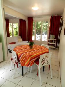 - une salle à manger avec une table, des chaises et un lit dans l'établissement Les Argousiers, à Le Touquet-Paris-Plage