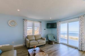 Una sala de estar con un sofá y vista al mar. en 129 North Shore Boulevard East Sandwich - Cape Cod, en East Sandwich
