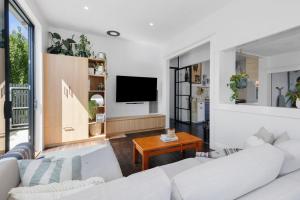 Belmont的住宿－Bellarine cottage- Central Geelong, parking, 2 bedroom, 2 bathroom，客厅配有2张白色沙发和电视