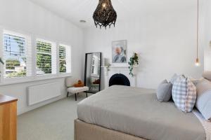 a bedroom with a bed and a fireplace and a chandelier at Bellarine cottage- Central Geelong, parking, 2 bedroom, 2 bathroom in Belmont