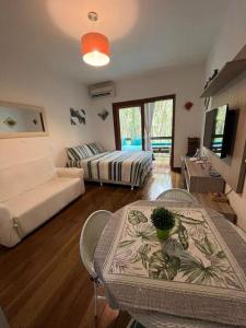 a living room with a bed and a table and chairs at Casa Maresias -Condomínio Reserva Mata Azul 100 metros da Praia in São Sebastião
