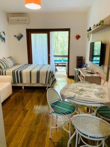 a living room with a bed and a table and chairs at Casa Maresias -Condomínio Reserva Mata Azul 100 metros da Praia in São Sebastião +58 photos