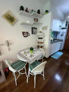 a kitchen with a table and chairs in a kitchen at Casa Maresias -Condomínio Reserva Mata Azul 100 metros da Praia in São Sebastião