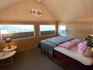 ein Schlafzimmer mit einem Bett in einem Zimmer mit Fenstern in der Unterkunft Lachende Eule in Hohentauern