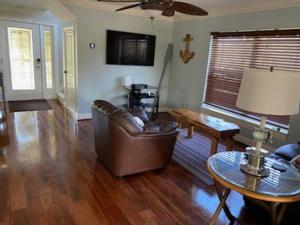 a living room with a leather couch and a table at 4BR Private Dock, Warm Spring Canal, Kayaks, Canoe in Hudson