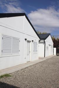 un edificio blanco con dos puertas de garaje en Pueblo Dorado Departamentos en Malargüe