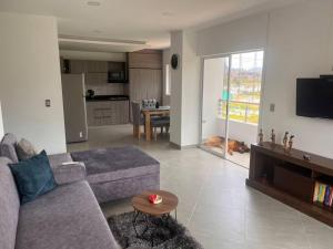 a living room with a couch and a table and a tv at Hermoso y amplio apartamento en Guatapé in Guatapé