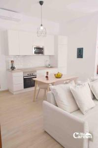 a white kitchen with a white couch and a table at Bonita casa en el corazón del pueblo! Villa Carmen in Garachico