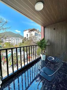 balcón con mesa, silla y piscina en Tuấn Ninh Hotel II en Con Dao