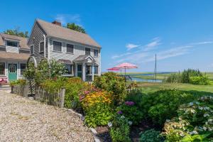 a house with a garden with flowers and an umbrella at 7 Sunrise Lane Sandwich Cape Cod - - Sunrise Vista in Sandwich