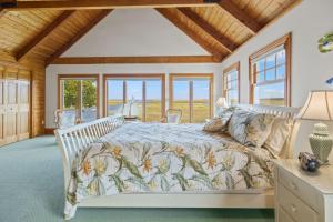 a bedroom with a bed with a comforter and windows at 7 Sunrise Lane Sandwich Cape Cod - - Sunrise Vista in Sandwich