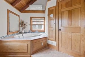 a bathroom with a large tub and a wooden door at 7 Sunrise Lane Sandwich Cape Cod - - Sunrise Vista in Sandwich