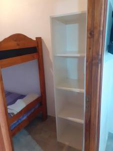 a book shelf in a room with a bunk bed at Departamento Rosales Nro 2 in Valeria del Mar