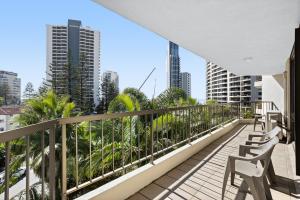 a balcony with chairs and a view of the city at Genesis Apartments in Gold Coast