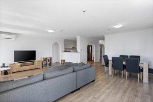 sala de estar con sofá y mesa con sillas en Genesis Apartments by Gold Coast Premium, en Gold Coast
