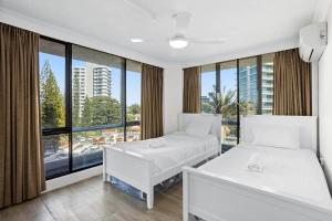 2 camas en una habitación con ventana grande en Genesis Apartments by Gold Coast Premium, en Gold Coast