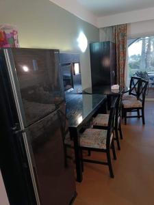Il comprend une cuisine équipée d'une table et d'un réfrigérateur noir. dans l'établissement Bellissimo appartamento vista mare sulla piscina, à Charm el-Cheikh