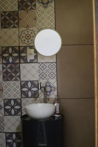 uma casa de banho com lavatório, candeeiro e azulejos em Casa de Roça em São João Batista do Glória