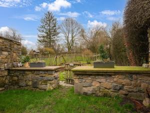 una pared de piedra en un jardín con una valla en Beautiful holiday home in Tinlot with garden, en Tinlot