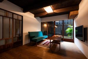 a living room with a green chair and a table at Rinn Shiki Juraku in Kyoto