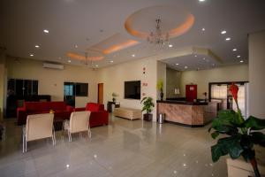 un gran vestíbulo con un sofá rojo y sillas en Atrium Express Hotels en Parauapebas