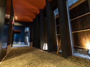 a hallway with columns in a building with a light at HALE Kyoto Toji#Tabist in Kyoto