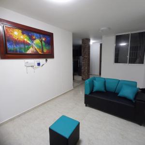 a living room with a couch and a painting on the wall at confortable apto integrado con la naturaleza y muy tranquilo perfecto para descansar in Socorro