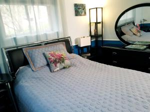 Un dormitorio con una cama con espejo y flores. en Private Retreat Apartment in DC en Washington