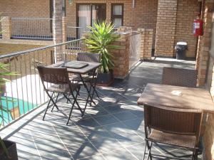 a patio with a table and chairs on a balcony at Uitsigpark Guest@home4U in Centurion