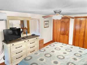 Un dormitorio con una cama y un televisor de pantalla plana. en 180 Hardings Beach Road Chatham Cape Cod - The Cape Escape, en Chatham