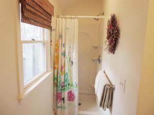 a bathroom with a shower curtain and a window at 142 George Ryder Road South Chatham Cape Cod - - Sweet Serenity in Chatham +28 photos