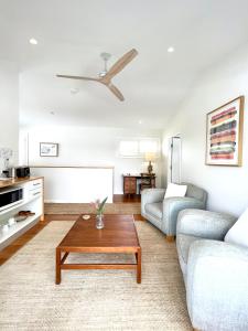 uma sala de estar com um sofá e uma mesa de centro em The Beach Shack Byron Bay em Byron Bay