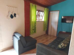 un salon avec un canapé et une chaise dans l'établissement Casa de Campo Pedra Bicuda, à Brazópolis